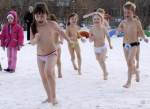 Copii alearga veseli, dezbracati pe
zapada, iarna, afara, la ora de educatie
fizica, la o scoala sau gradinita din
Rusia